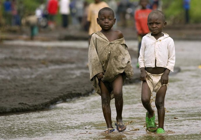 Dos niños pequeños caminan por una de las carreteras afectadas por las últimas inundaciones que ha sufrido la capital de la República Democrática del Congo, Kinsasa.