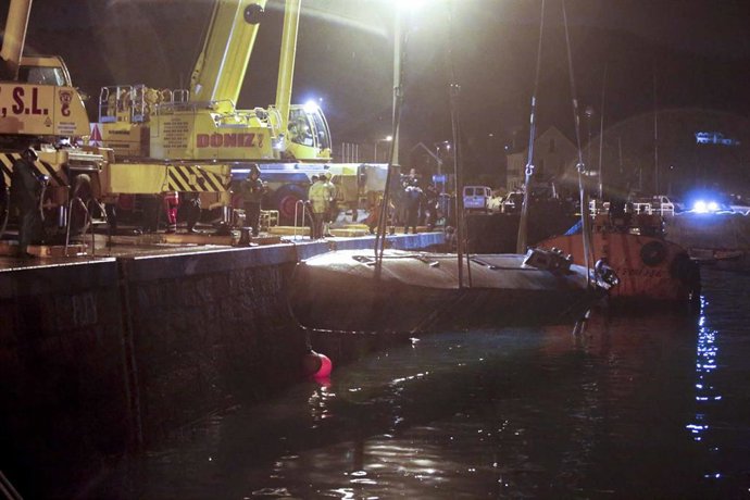 Dos grandes grúas izan desde el muelle de Aldán, en Cangas (Pontevedra), el 'narcosubmarino' localizado en Punta Couso el 23 de noviembre.