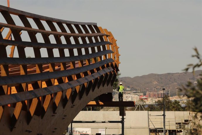 Instalación de los primeros tramos de la pasarela de madera sobre el río Guadalhorce
