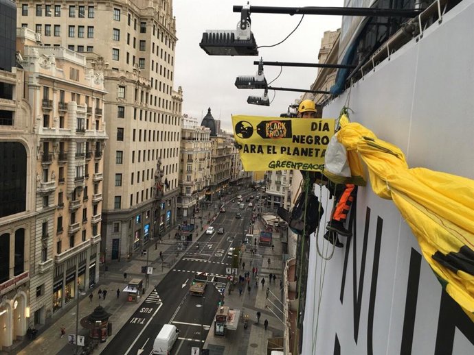 Imagen de la colocación de la pancarta contra el consumo masivo de Greenpeace en la Gran Va.