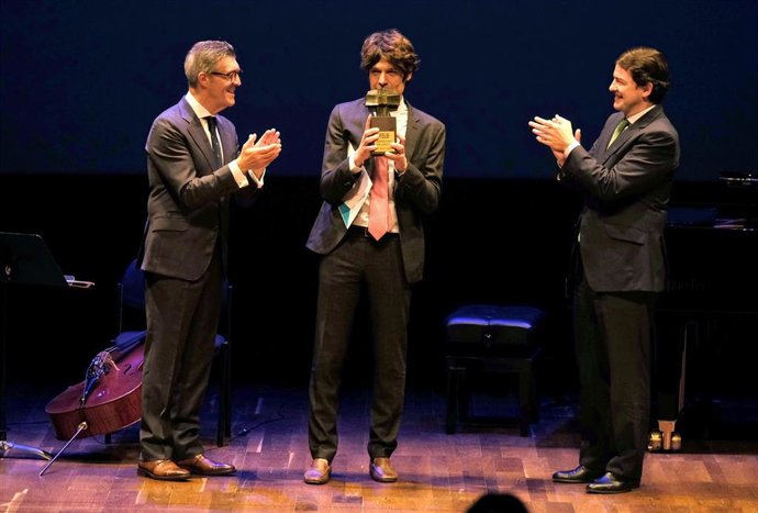 El presidente de la Junta de Castilla y León, Alfonso Fernández Mañueco, junto al preamiado, Lucas Sigman, y el presidente de la FELE, Javier Cepedano.