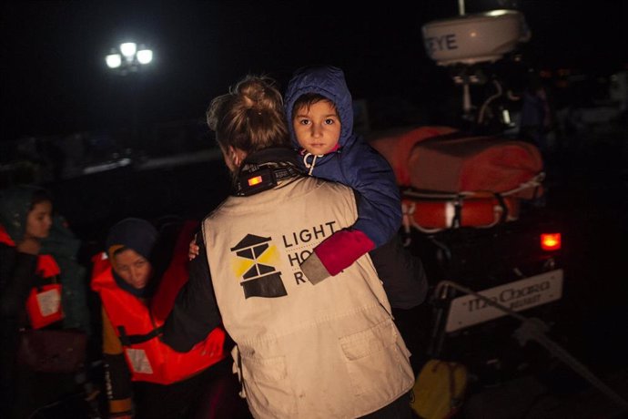 27 November 2019, Greece, Lesbos: A volunteer holds a baby as migrants disembark a lifeboat of the Refugee Rescue NGO at the port of Skala Sikamias on the island of Lesbos, after a rescue operation by a Frontex patrol vessel. Photo: Angelos Tzortzinis/d