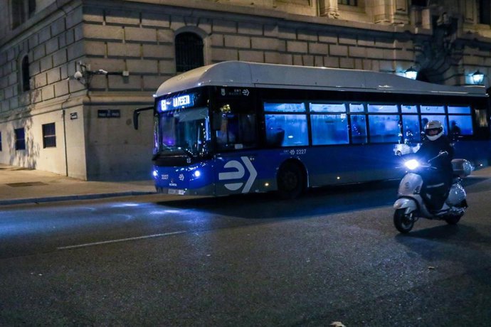 Una moto circula junto a un autobús de la línea E1 en una calle de Madrid.