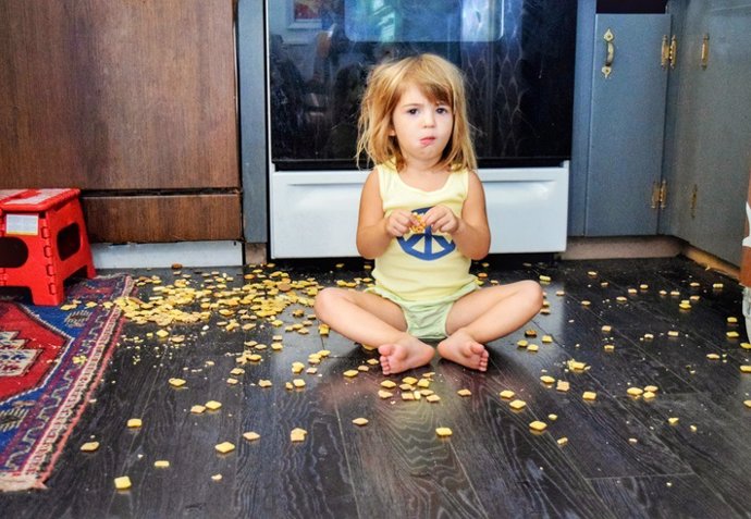 Niña comiendo del suelo.