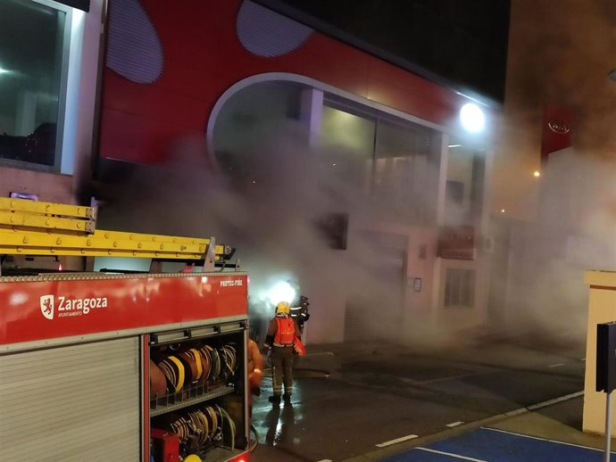 Bomberos de Zaragoza sofocan un incendio en un almacén de repuestos de vehículos en la carretera de Madrid.