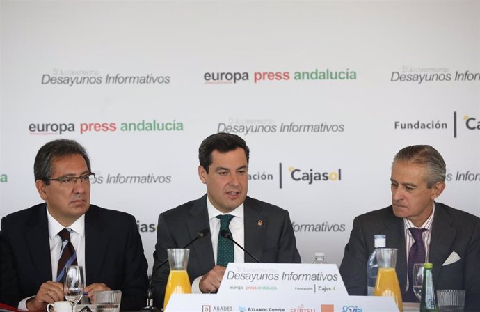 El presidente de la Junta de Andalucía, Juanma Moreno (c), junto al  el presidente de Europa Press, Asís Martín de Cabiedes(d)  y el presidente de la Fundación Cajasol, Antonio Pulido (i), durante los desayunos Informativos de Europa Press Andalucía