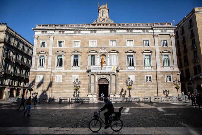 Plano general de la fachada de la Generalitat de Catalunya tras el cambio de la antigua pancarta del balcón central en la que aparecía un lazo amarillo por otra con la misma frase (en la que insta a la libertad de los presos políticos) pero con un lazo 