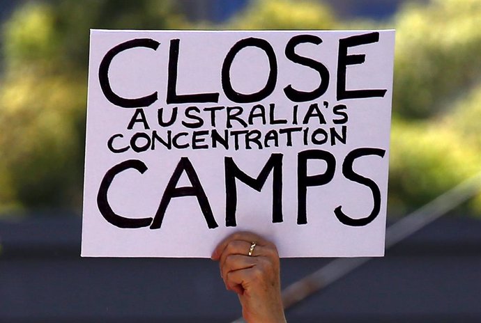 Un manifestante sostiene una pancarta en apoyo a los refugiados que el Gobierno de Australia mantiene en campamentos situados en islas remotas del Pacífico.