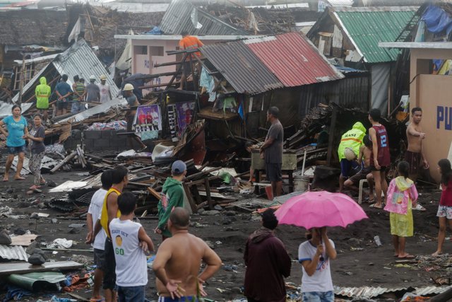 Residents stand among their damaged houses after Typhoon Kammuri hit Legazpi City, Albay, Philippines