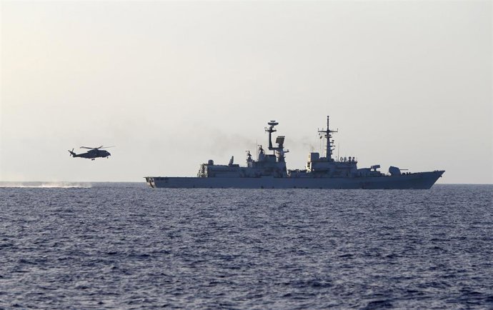 Un helicóptero y un navío pertenecientes a la flota naval italiana navegando cerca de las costas de Libia.