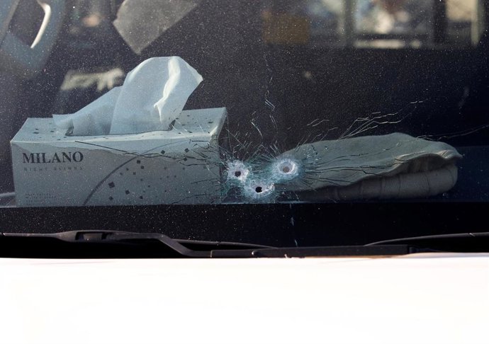 Bullet holes are seen in the window of the vehicle carrying Japanese doctor Tets