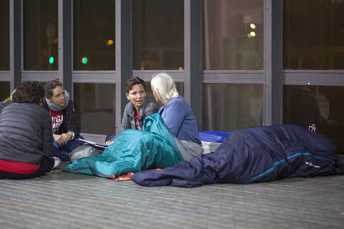 Voluntaris d'Arrels entrevisten una dona sense llar a Barcelona.