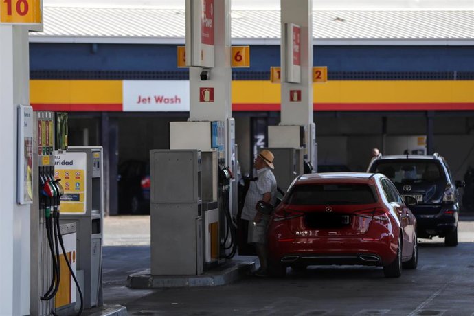 Personas ponen gasolina en sus coches en una gasolinera de Madrid.