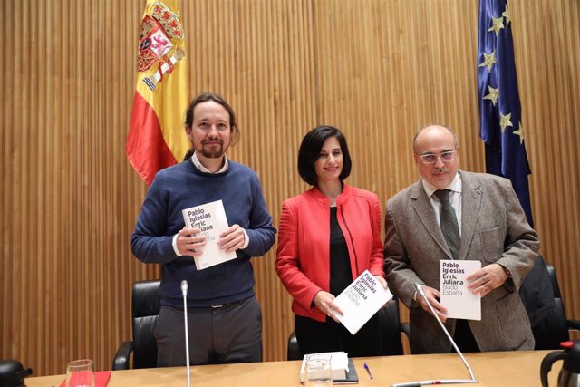 (I-D) El secretario general de Podemos, Pablo Iglesias; la periodista Lola García como moderadora y el periodista Enric Juliana posan con el libro del evento durante el diálogo `Nudo España: un año después en el Congreso de los Diputados