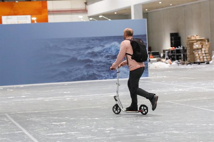 Una persona en patinete en uno de los pabellones de la Feria de Madrid, IFEMA, en los preparativos de la Cumbre del Clima que comenzará el próximo día 2 de diciembre, en Madrid (España), a 29 de noviembre de 2019.