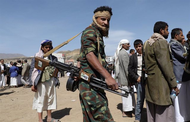 Un seguidor huti prta un arma durante la entrega de avituallamientos en Saná.