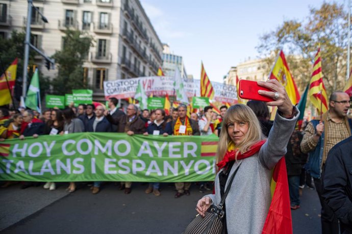Una assistent a la manifestació per la Constitució a Barcelona es fa una foto davant d'una de les pancartes, que diu 'Avui com ahir, catalans i espanyols', Barcelona (Catalunya/Espanya) 6 de desembre del 2019.