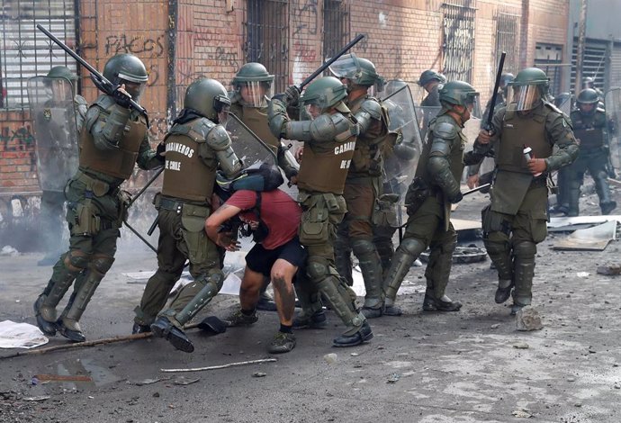 Agentes del Cuerpo de Carabineros reducen a un manifestante durante las protestas en Santiago, Chile.
