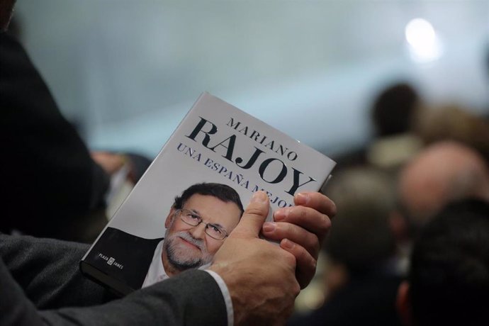 Una persona sostiene el libro del expresidente del Gobierno Mariano Rajoy, "Una España Mejor", durante su presentación en la Fundación Rafael del Pino, en Madrid a 4 de diciembre de 2019.