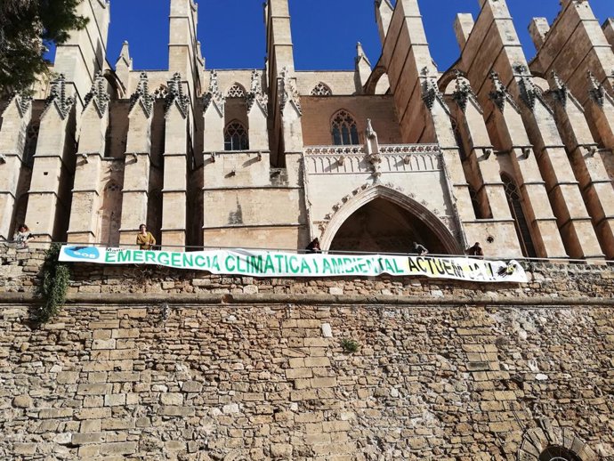 El GOB desplega una pancarta per l'emergncia climtica davant la Catedral de Palma.
