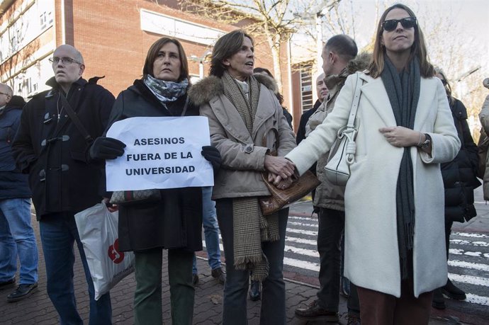 Una mujer sostiene un cartel en el que se lee "Asesinos fuera de la Universidad", durante la concentración de la Asociación Esteban de Garibay por la charla del expreso de ETA José Ramón López Abetxuko, a las puertas de la UPV/EHU en Vitoria