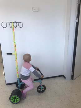 menor ingresado en Oncología juega con un triciclo donado