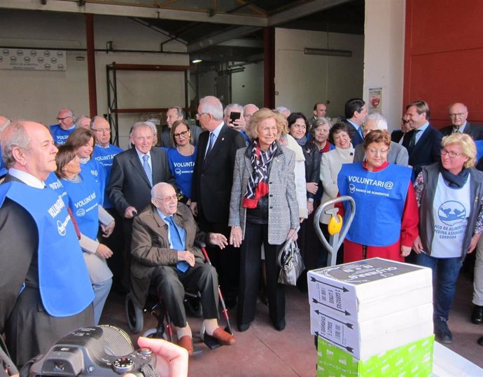 La Reina Sofia (centro), rodeada de voluntarios del Banco de Alimentos de Córdoba y autoridades durante su visita.