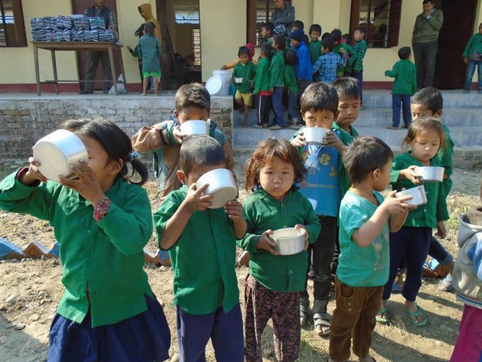 Niños tomando gofio con agua en Nepal