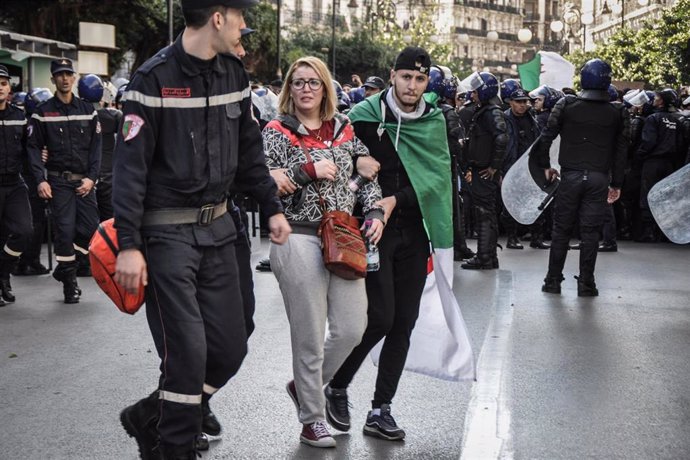 La Policía arresta a una manifestante en una protesta ante un centro electoral en Argel durante las elecciones presidenciales