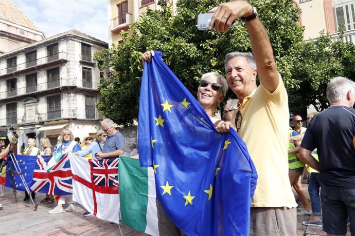 Una pareja se toma un selfie junto a la bandera de europea en Málaga durante una protesta contra el Brexit