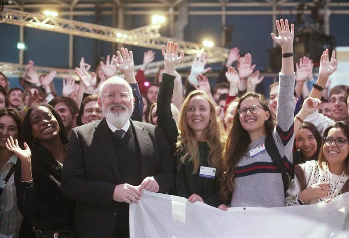 El vicepresidente primero de la Unión Europea, Frans Timmermans, posa con jóvenes activistas durante la undécima jornada de la Cumbre del Clima (COP25) en Ifema, Madrid (España), a 12 de diciembre de 2019.