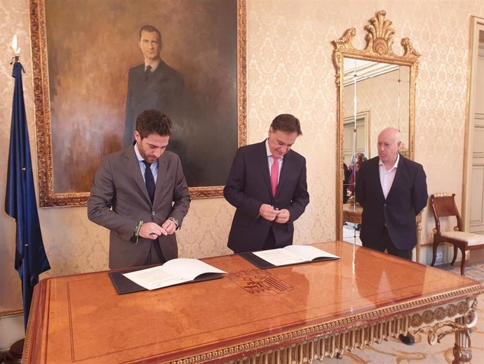 César Pontvianne (i) firma un acuerdo de colaboración con el alcalde de Salamanca, Carlos García Carbayo (c) en el Consistorio salmantino.