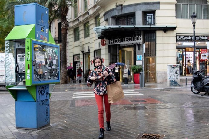 Una chica pasea por la calle abrigada con bufanda y abrigo durante el peor temporal del otoño del 2019 en España en el que se verán afectadas 37 provincias avisadas por viento, nieve, oleaje o lluvia, en Madrid (España),  a 14 de noviembre de 2019.