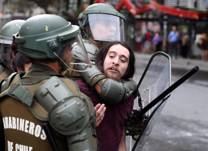 Un manifestante es reducido por Carabineros en las protestas acontecidas en Santiago, Chile.