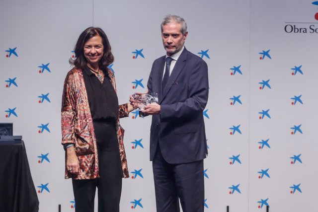 La presidenta de Manos Unidas, Clara Pardo Gil, entrega el premio al director de Europa Press, Javier Garcia Vila. 