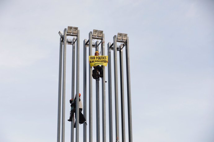 Activistas de Greenpeace escalando las torres de iluminación del parking de IFEMA, en Madrid