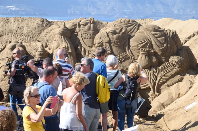 Un grupo de turistas visitan el Belén de Arena de la playa de Las Canteras tras su inauguración