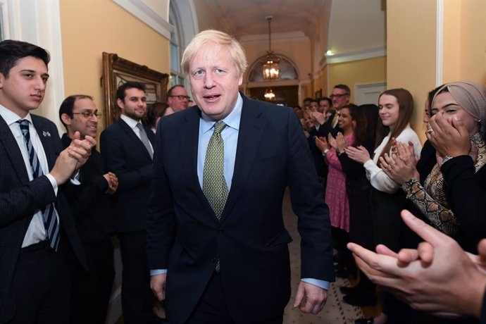 13 December 2019, England, London: Staff of 10 Downing Street greet UK Prevalgui Minister Boris Johnson upon his arrival from Buckingham Palace where he was invited by Queen Elizabeth II to form a Government, after the Conservative Party was returned wi