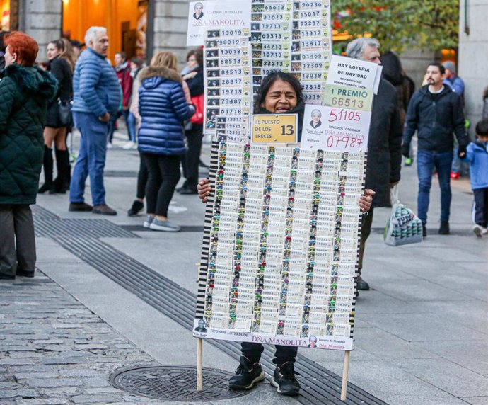 Una mujer vende décimos de Lotería de Navidad de la Administración de Doña Manolita, en Madrid (España), a 18 de noviembre de 2019.