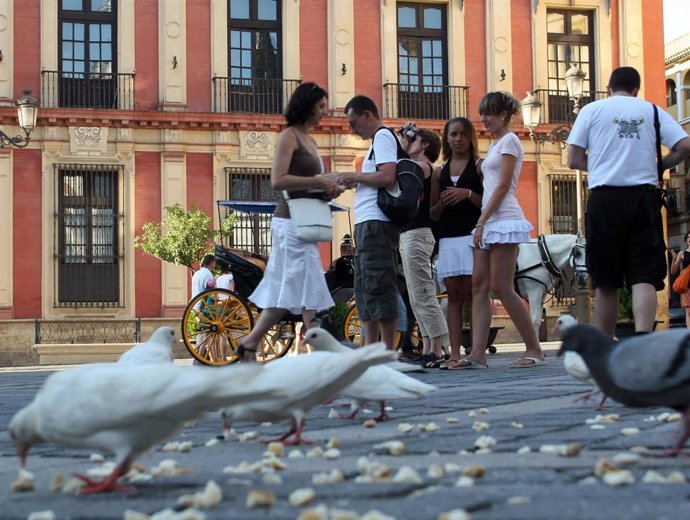 Turistas recorriendo Sevilla