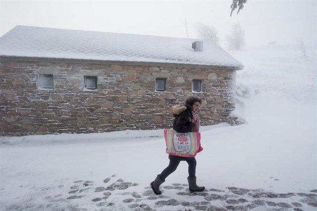 Una peregrina se dirige con la compra y entre la nieve a un albergue de peregrinos, en el municipio de Pedrafita do Cebreiro, en Lugo-País Vasco (España), a 17 de diciembre de 2019.