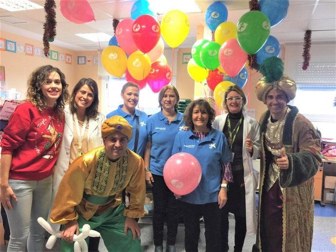 Los voluntarios de 'la Caixa' entregan regalos de Navidad a menores hospitalizados
