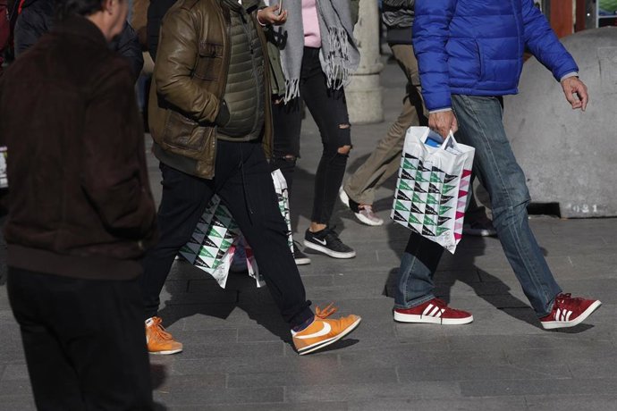 Fotos de recurso de varias personas cargan bolsas de establecimientos y grandes superficies, ultimando los regalos para el día de Reyes 