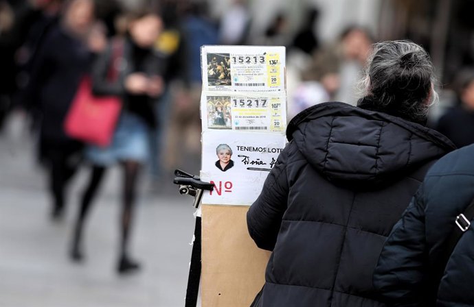 Una lotera al costat del seu lloc de venda de bitllets de Loteria de Nadal a la Plaa del Sol de Madrid (Espanya), a 16 de desembre del 2019 .