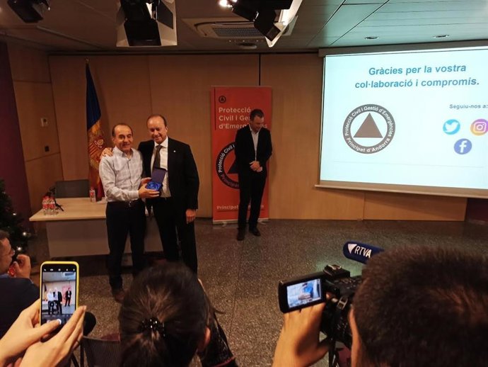 L'exdirector de Protecció Civil, Francesc Areny, rep una placa de reconeixement de mans del ministre de Justícia i Interior, Josep Maria Rossell.