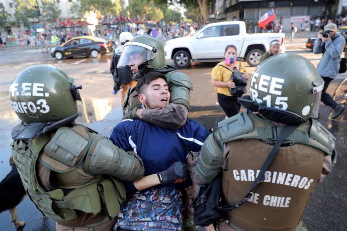 Un manifestante es reducido por agentes de los Carabineros durante la última manifestación en contra del Gobierno celebrada en Santiago, Chile.