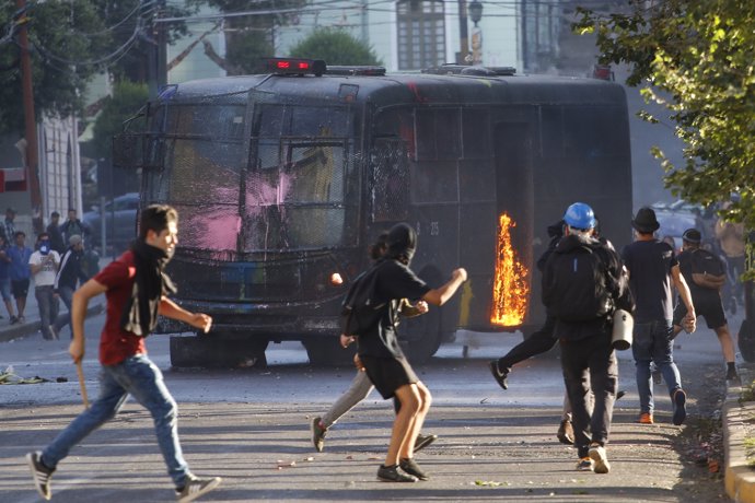 18 December 2019, Chile, Valparaiso: A police car burns during clashes between Anti-government demonstrators and security forces following a protest against the Chilean government. Photo: Matias Pina/Agencia Uno/dpa