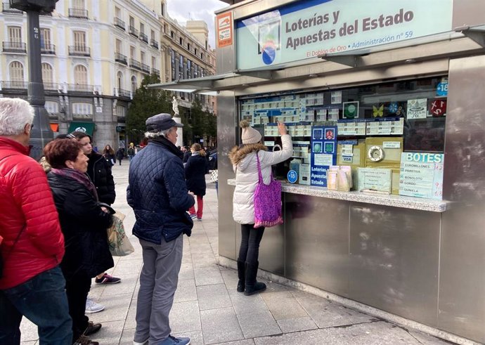 Una mujer compra un décimo de Lotería de Navidad en una Administración en la plaza de Puerta del Sol, en Madrid (España), a 18 de noviembre de 2019.
