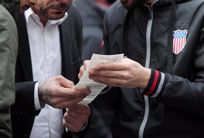 Un grup d'amics mira el nombre del bitllet de Loteria de Nadal que han comprat a la Plaza del Sol de Madrid (Espanya), a 16 de desembre del 2019 .