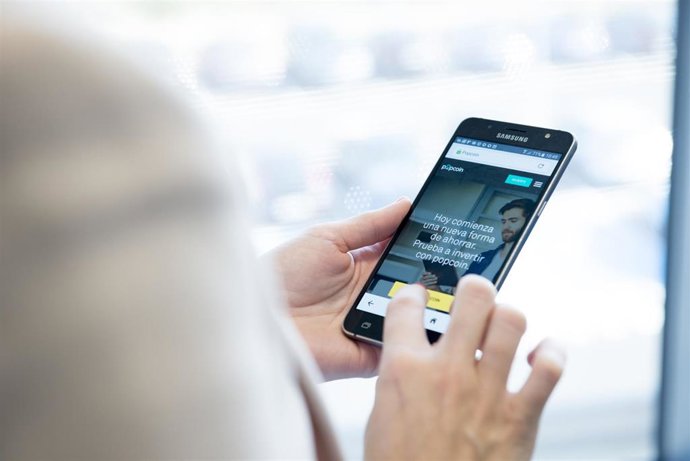 Una persona opera en su móvi Popcoin, el roboadvisor de Bankinter